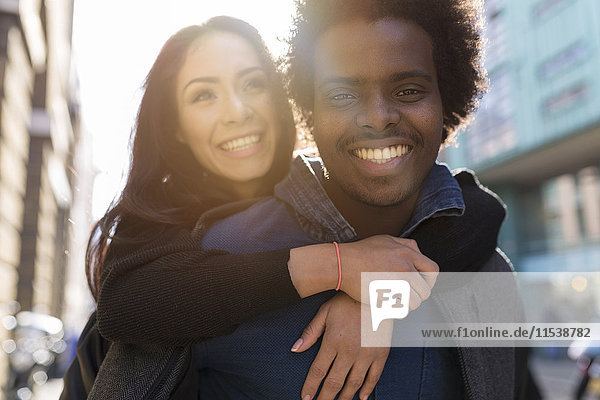 Happy young man carrying girlfriend piggyback