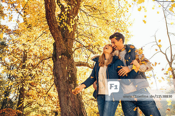 Happy couple having fun in autumn in a forest