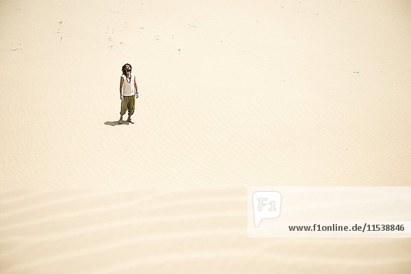 Mann steht allein in der Wüste
