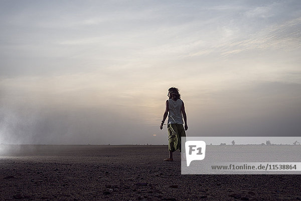 Man standing in the desert watching sunrise