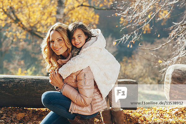 Portrait of mother and her little daughter in autumn