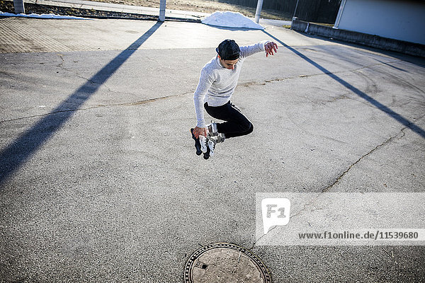 Young man jumping with inlineskates