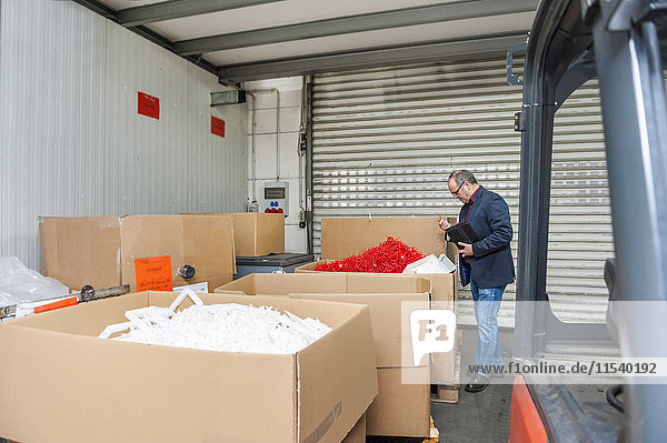 Manager in storage of plastics factory checking products