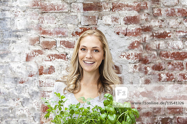 Portait of smiling blond woman with herbs