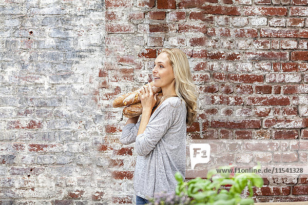 Blond woman carrying baguettes