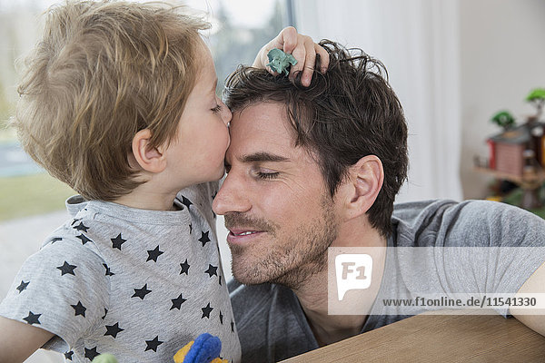 Little boy stroking and kissing his father