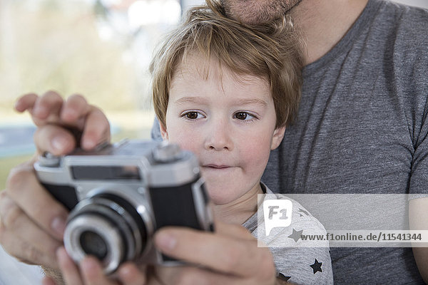 Father and son playing with camera