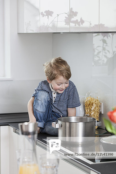 Kleiner Junge hilft bei der Zubereitung des Essens in der Küche