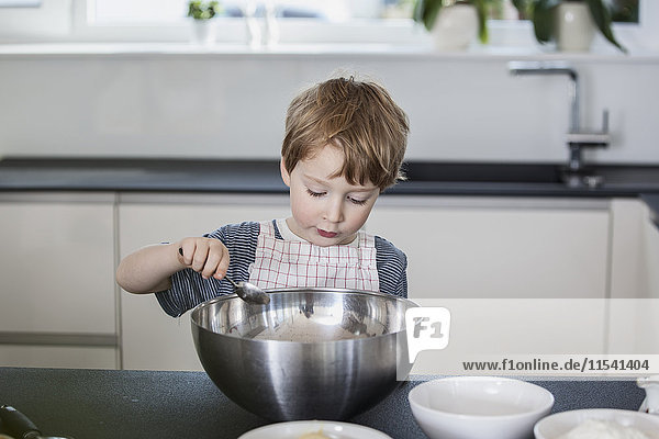 Kleiner Junge hilft bei der Zubereitung des Essens in der Küche