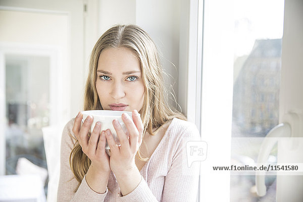 Portrait of blond woman with bowl of coffee