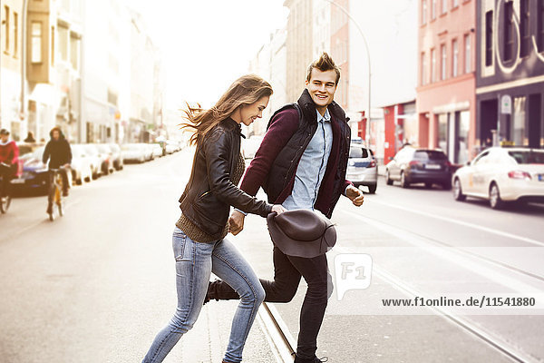 Deutschland  Berlin  glückliches Paar beim Überqueren einer Straße