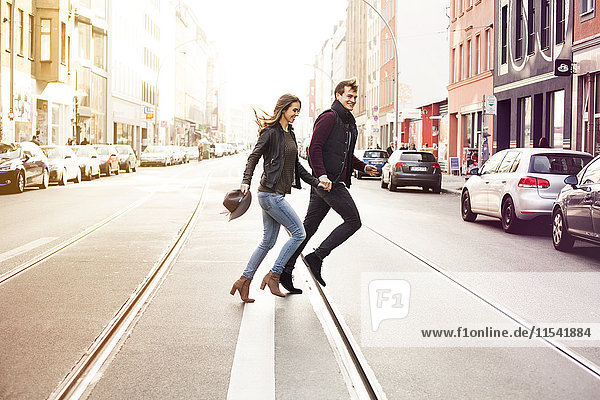 Germany  Berlin  happy couple crossing a street