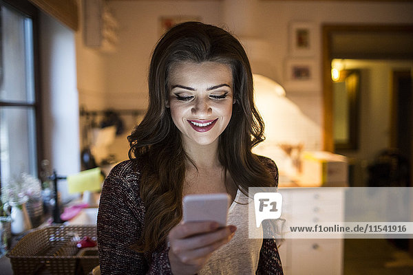Young woman at home using smartphone