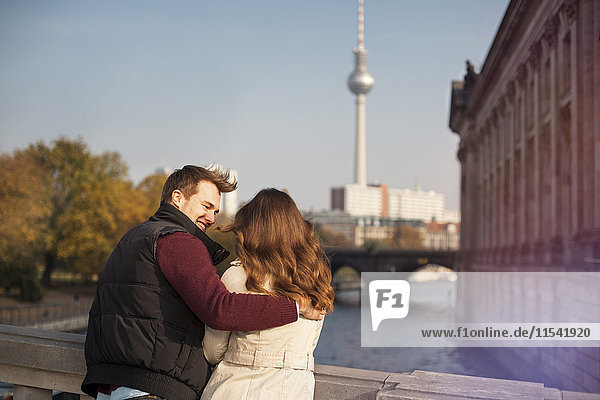 Germany  Berlin  young couple at River Spree with view to TV tower
