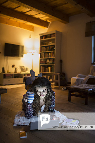 Junge Frau zu Hause bei der Arbeit mit dem digitalen Tablett