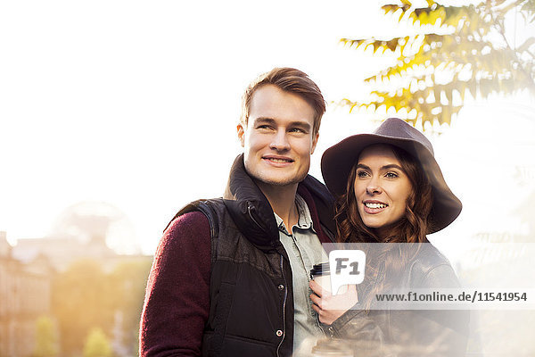 Smiling young couple with coffee to go