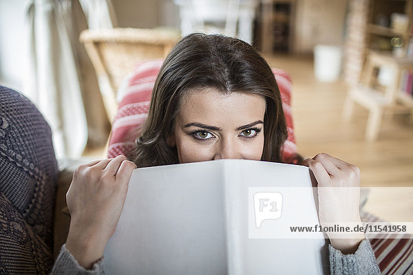 Junge Frau zu Hause beim Lesen eines Buches
