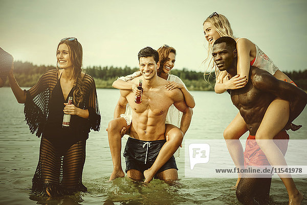 Deutschland  Haltern  Gruppe von fünf Freunden  die im Wasser des Silbersees stehen und sich gemeinsam amüsieren.