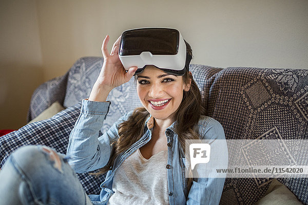 Young woman at home using Virtual Reality goggles