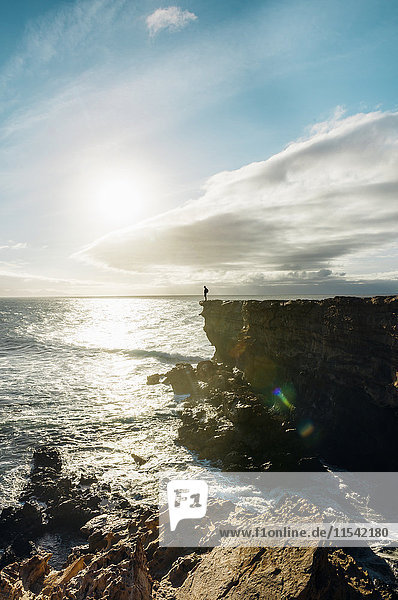 Spanien  Kanarische Inseln  Fuerteventura  La Pared  Mann auf einer Klippe bei Sonnenuntergang stehend