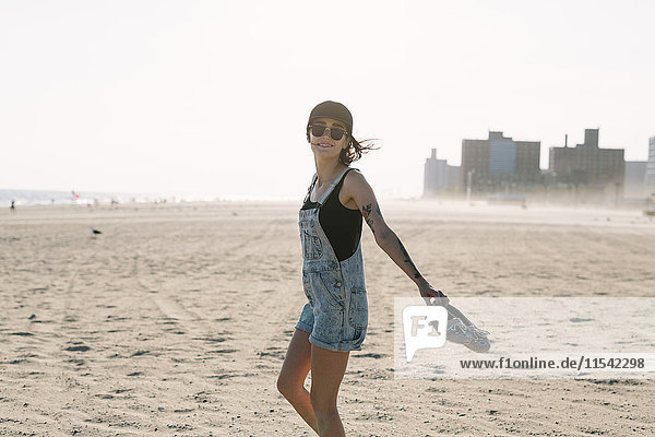 USA  New York  Coney Island  junge Frau am Strand bei Sonnenuntergang