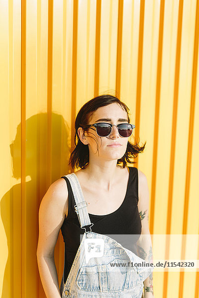 Young woman standing against a yellow wall