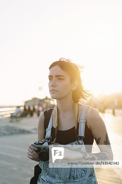 USA  New York  Coney Island  junge Frau fotografiert bei Sonnenuntergang