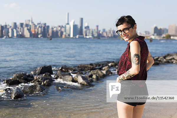 USA  New York City  Portrait einer jungen Frau vor der Skyline von Manhattan