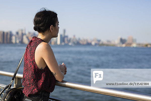 USA  New York City  Williamsburg  junge Frau an einem Geländer lehnend