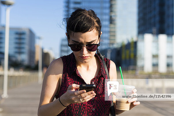 Portrait of young woman looking at her smartphone