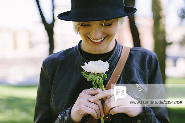 Smiling blond woman holding a flower