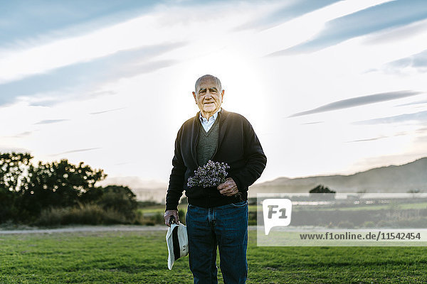 Spanien  Tarragona  älterer Mann mit Blumenstrauß auf dem Feld