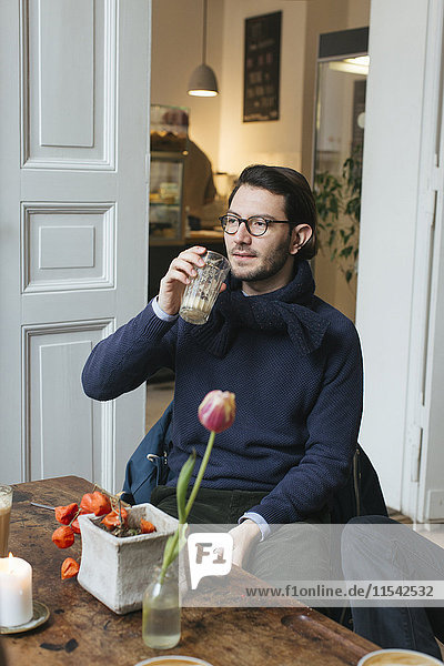 Mann im Café mit Latte Macchiato