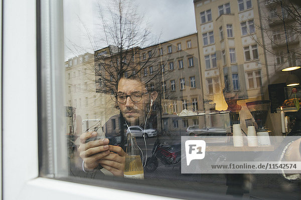 Mann im Café hinter der Fensterscheibe