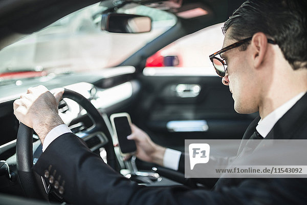 Businessman in car using cell phone