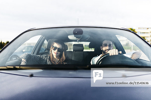 Junges Paar beim Autofahren