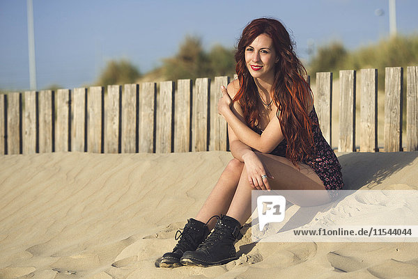Spain  Cadiz  portrait of young redheaded woman sitting on the beach