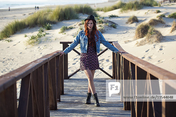 Spain  Cadiz  portrait of young redheaded woman standing on boardwalk at the beach