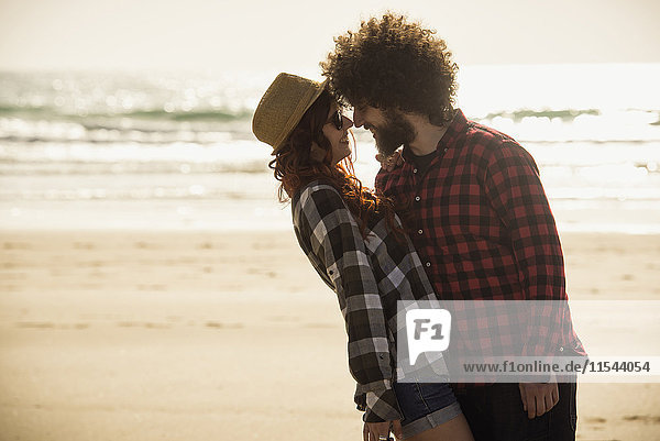 Spain  Cadiz  young couple in love standing face to face on the beach