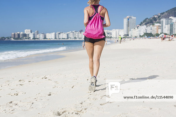 Brasilien  Rio de Janeiro  Rückansicht der Frau beim Joggen am Strand