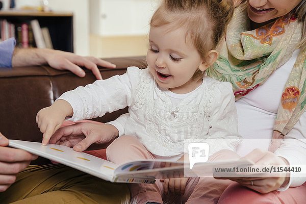 Eltern lesen Buch für kleines Mädchen