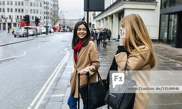 UK  London  Zwei Freunde erkunden die Stadt mit dem Smartphone