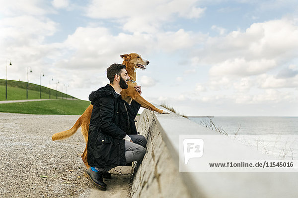 Man and his dog looking at the sea