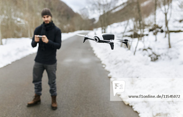 Spanien  Asturien  Mann auf einer Drohne in den schneebedeckten Bergen