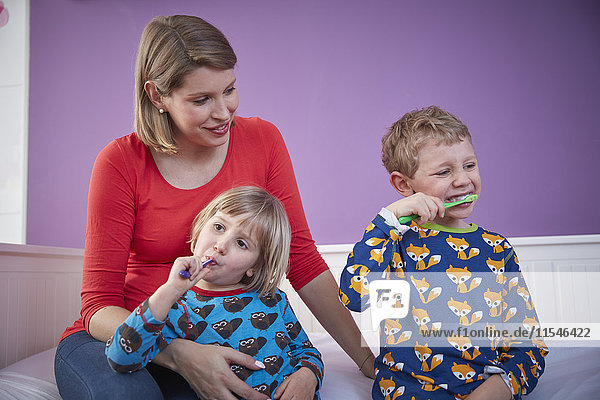 Mutter mit zwei Kindern beim Zähneputzen