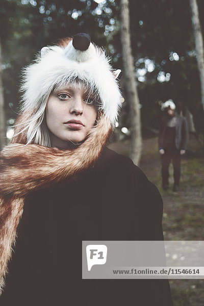 Porträt einer jungen Frau mit Fuchshut im Wald