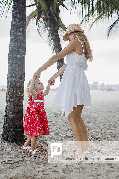 Brasilien  Rio de Janeiro  Mutter und Tochter spielen am Strand von Copacabana