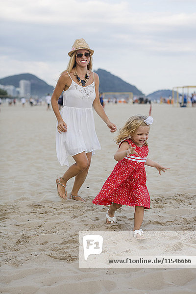 Brasilien  Rio de Janeiro  glückliche Mutter und Tochter am Strand von Copacabana