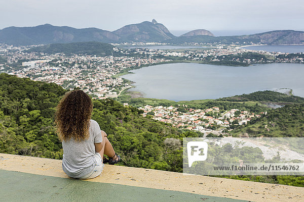 Brasilien  Frau sitzt auf einem Aussichtspunkt in Rio de Janeiro