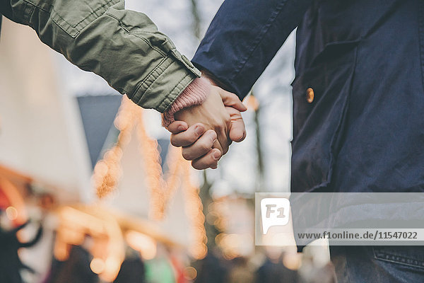 Close-up of couple holding hands on the Christmas Market